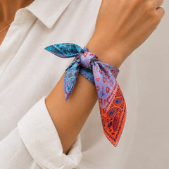A close-up of a person's wrist wearing a bandana tie, styled with a white collared shirt.