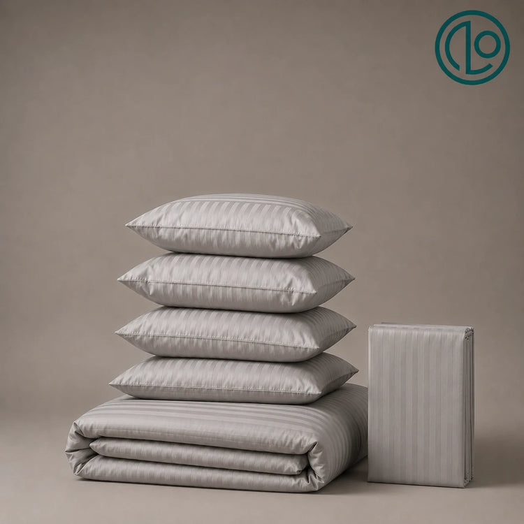 Stacked grey striped pillowcases and folded bed linen.