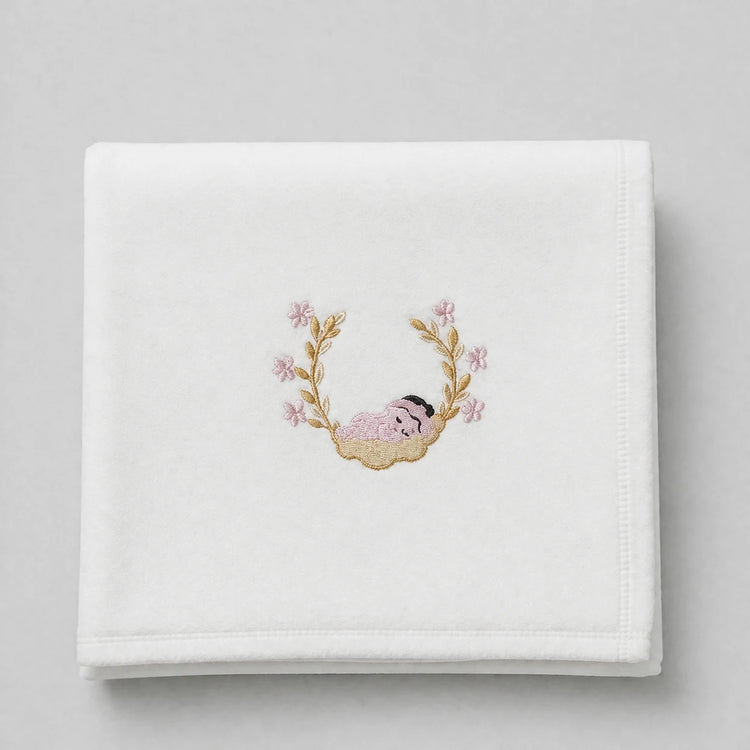 White blanket folded flat with a sleeping baby motif and pink floral branches