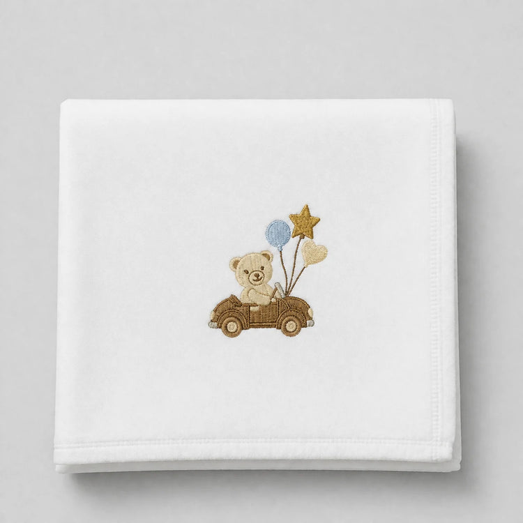 White blanket folded flat with a teddy bear in a car and balloons