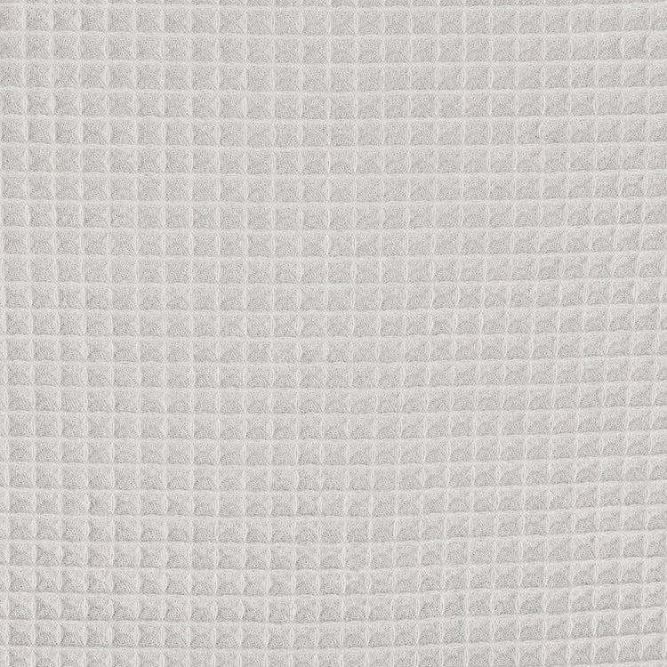Close-up of the light grey grid texture of a cotton thermal blanket.