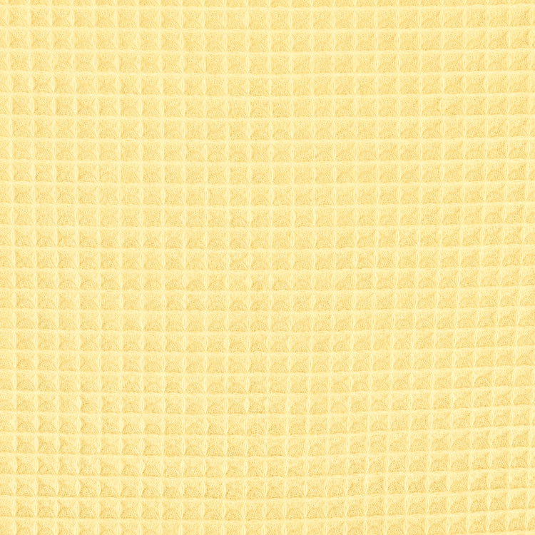 Close-up of the pale yellow grid texture of a cotton thermal blanket.