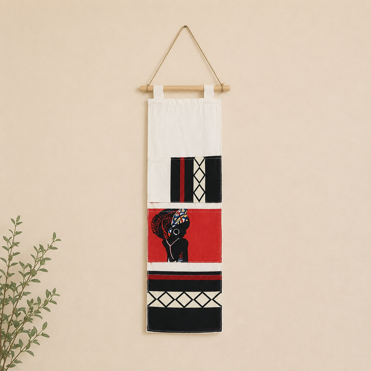Cream hanging wall organizer with black, red and white patterned pockets.