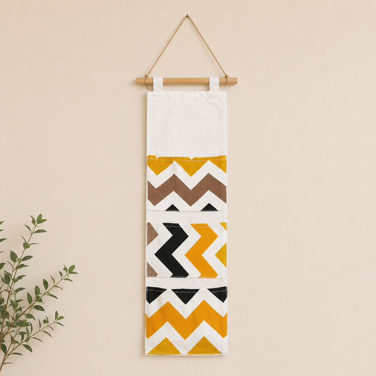 Cream hanging wall organizer with black and mustard chevron pockets.