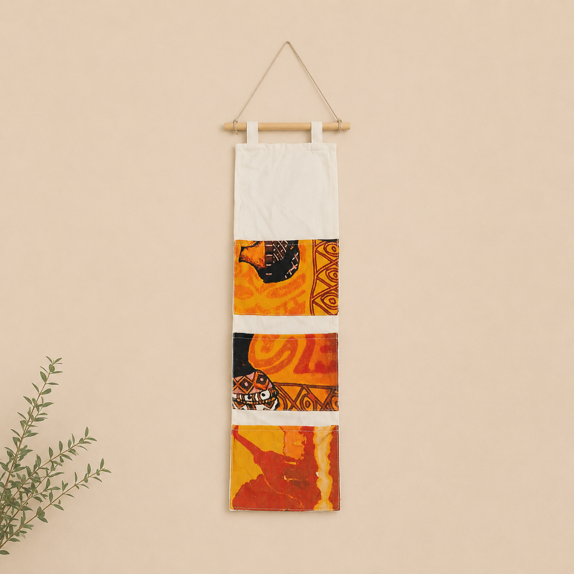 Cream hanging wall organizer with orange and yellow patterned pockets.