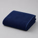 Folded navy bath towel on a light grey surface.