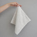 Cream hand towel held up by one corner.