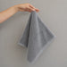 Grey hand towel held up by one corner.