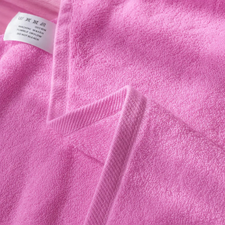 Close-up of the hem and texture of a pink cotton bath towel.