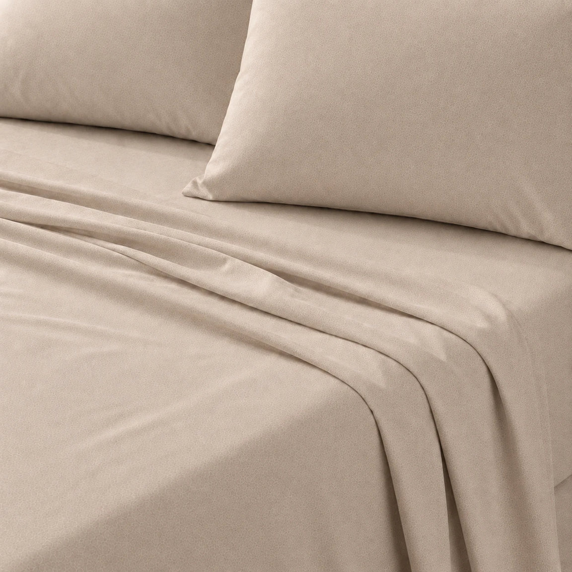 Close-up of sand beige bed linen and matching pillows on a bed.