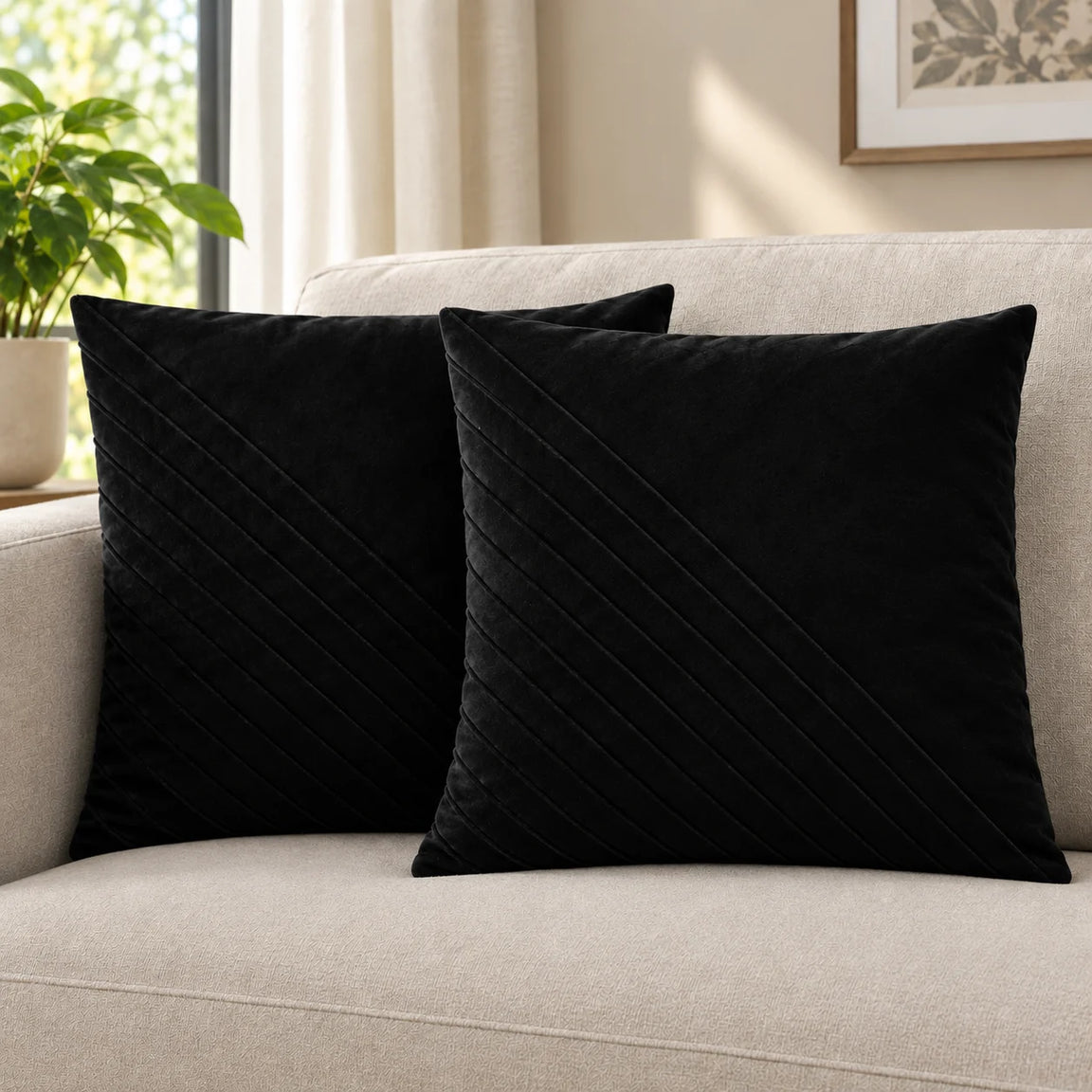 Two black cushion covers with diagonal stitched lines on a cream sofa.