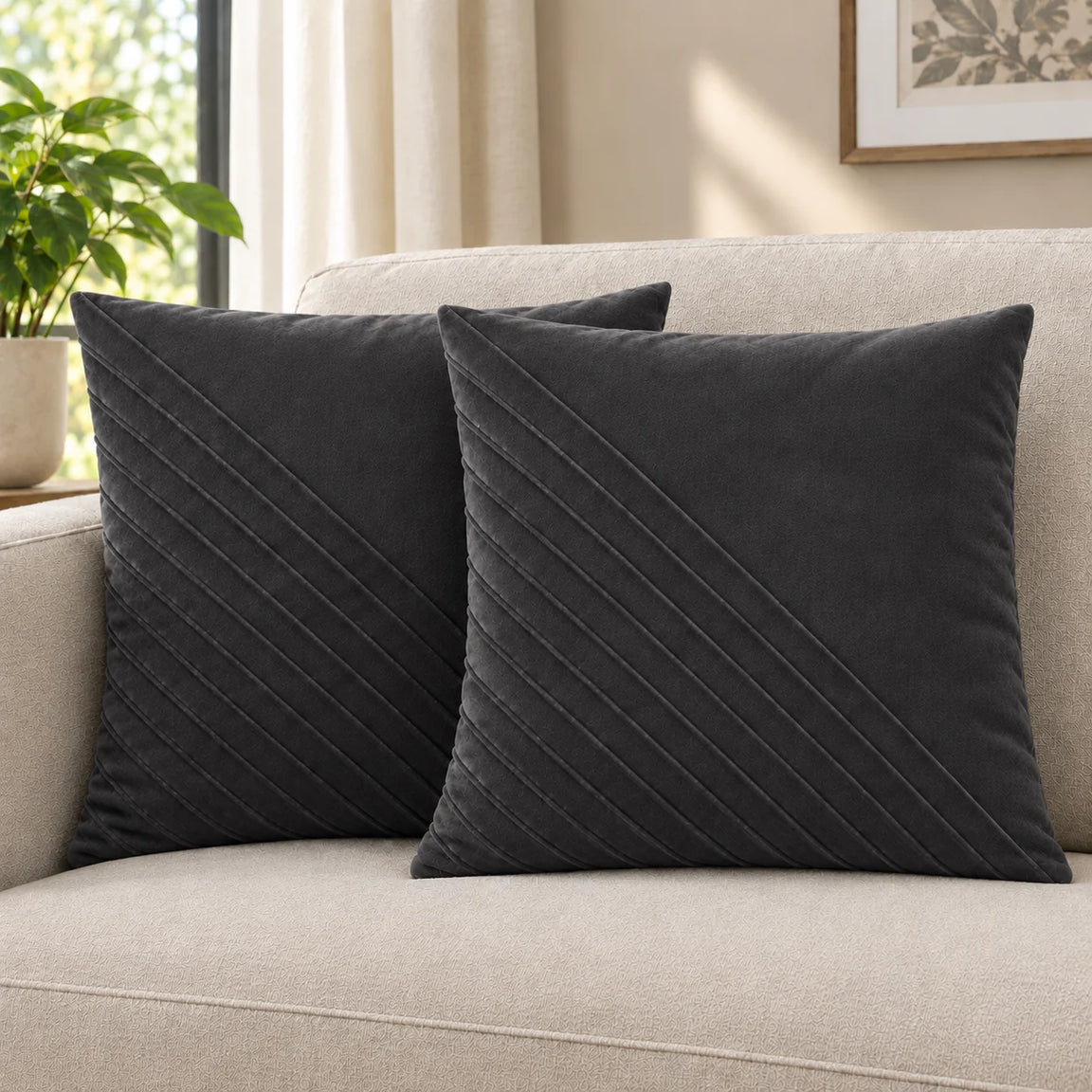 Two charcoal grey cushion covers with diagonal stitched lines on a cream sofa.