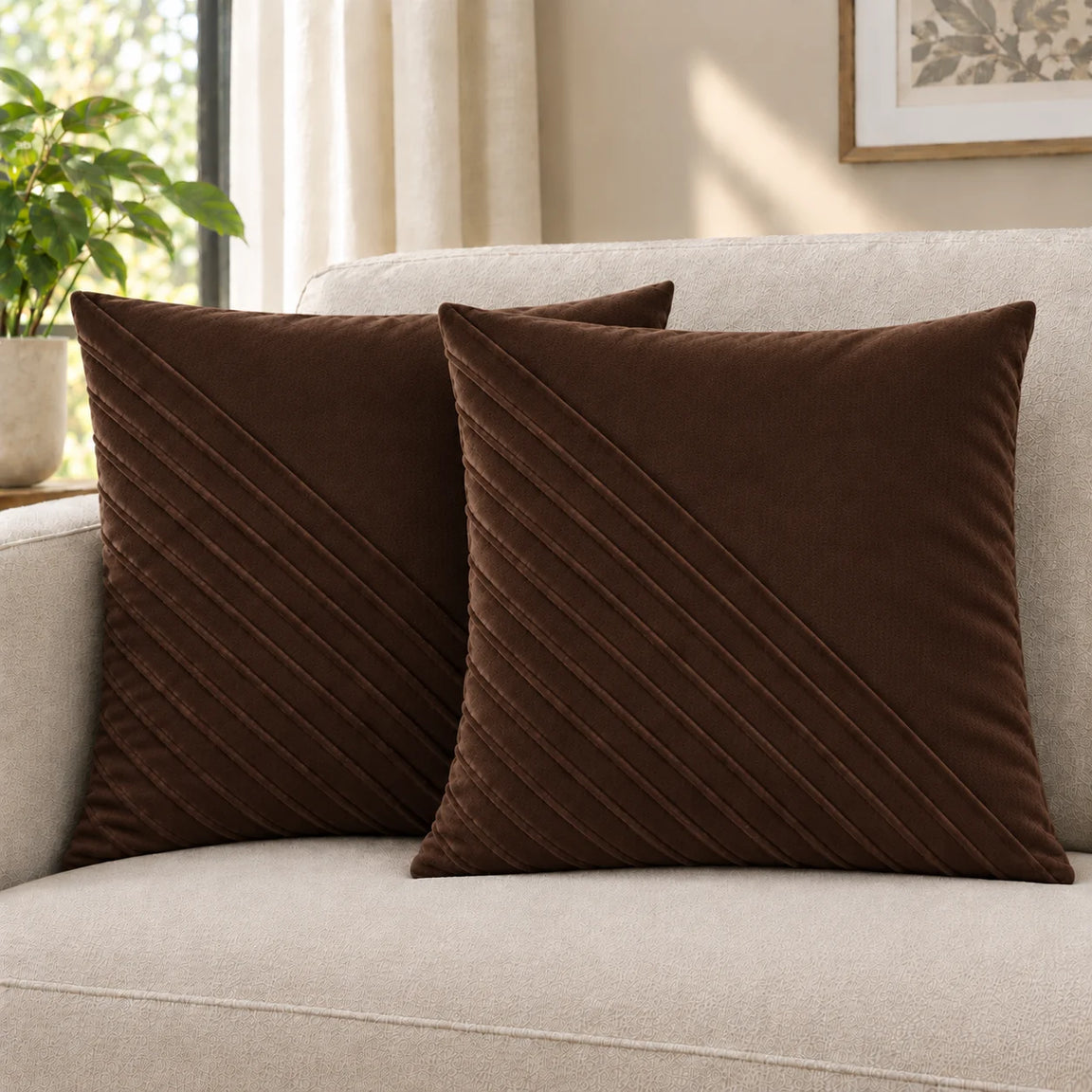 Two brown cushion covers with diagonal stitched lines on a cream sofa.