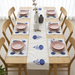 White table runner with blue stylised floral motifs and matching placemats.