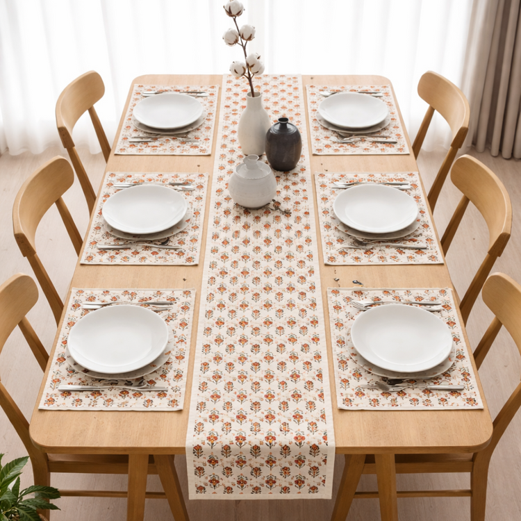 Cream table runner with small repeating red floral motifs and matching placemats.