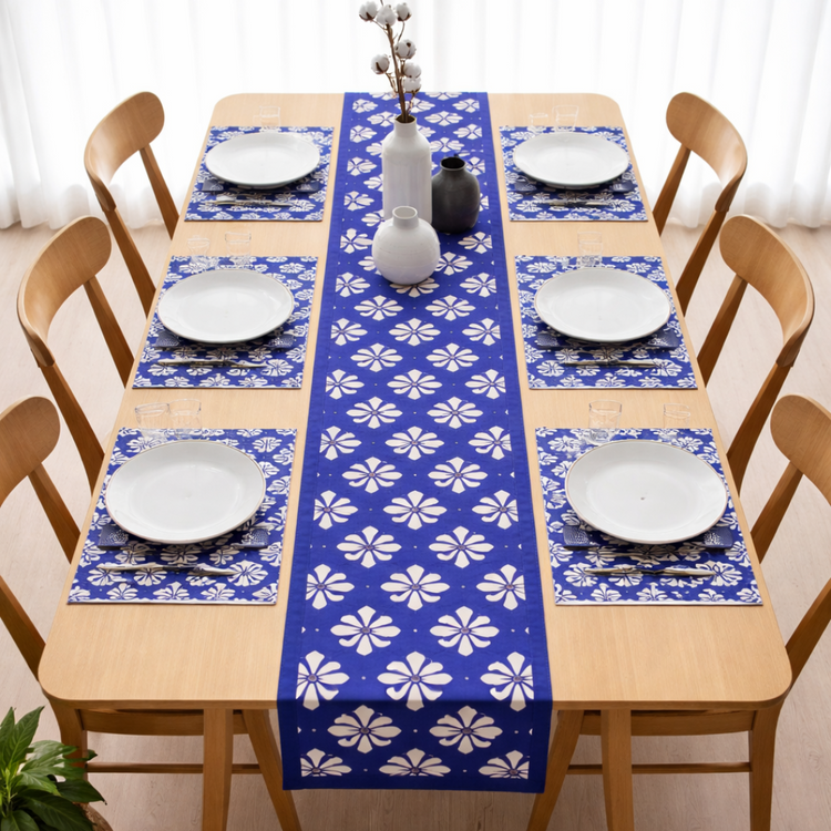 Blue table runner with white floral motifs and matching placemats.