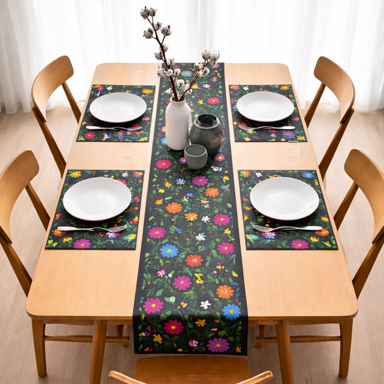Black table runner with bright floral motifs and matching placemats on a dining table.