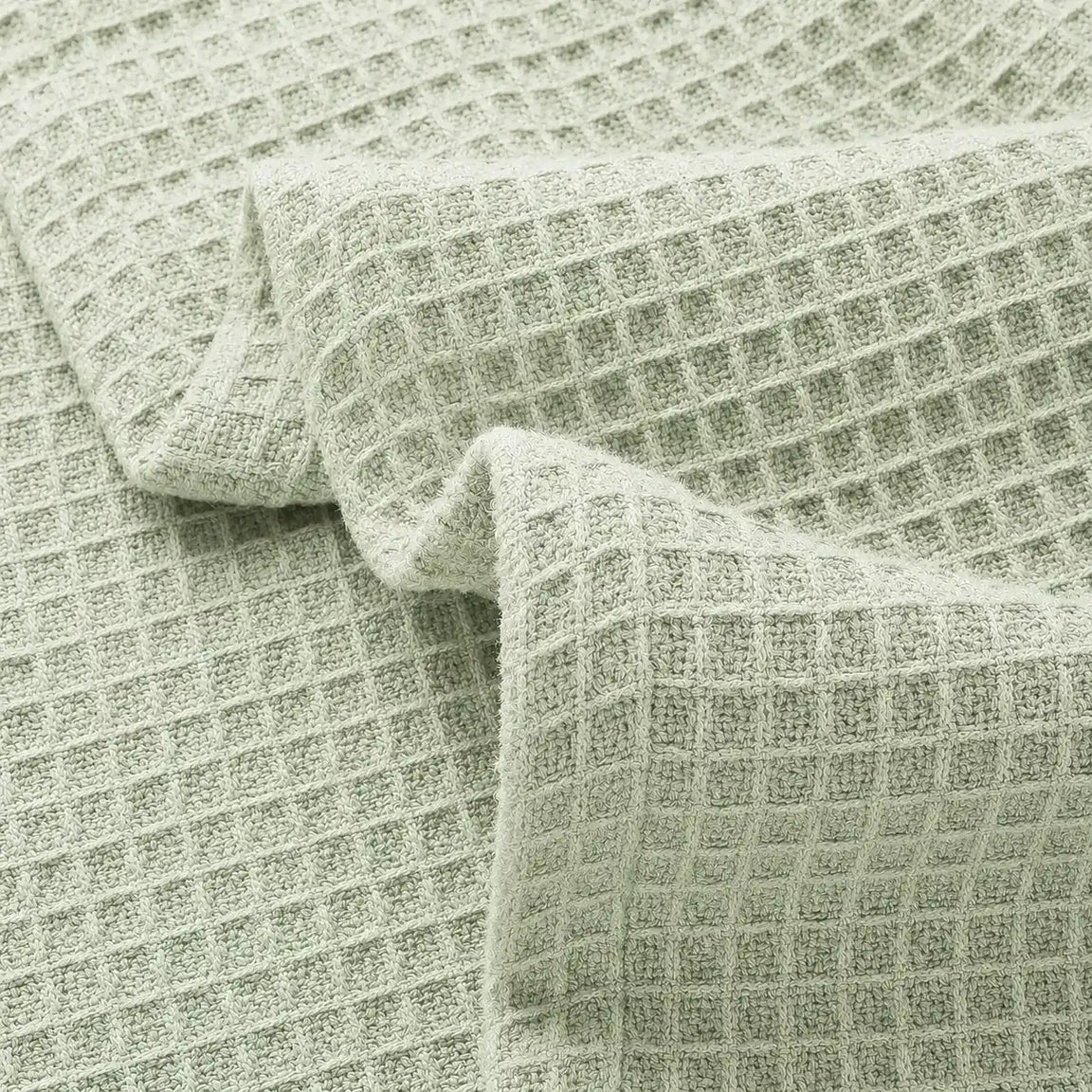 Close-up of pale green waffle-weave blanket fabric.