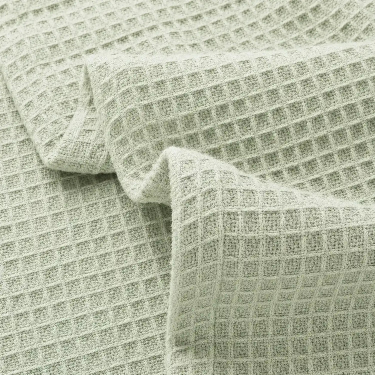 Close-up of pale green waffle-weave blanket fabric.