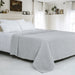 Light grey textured cotton thermal blanket spread across a bed.