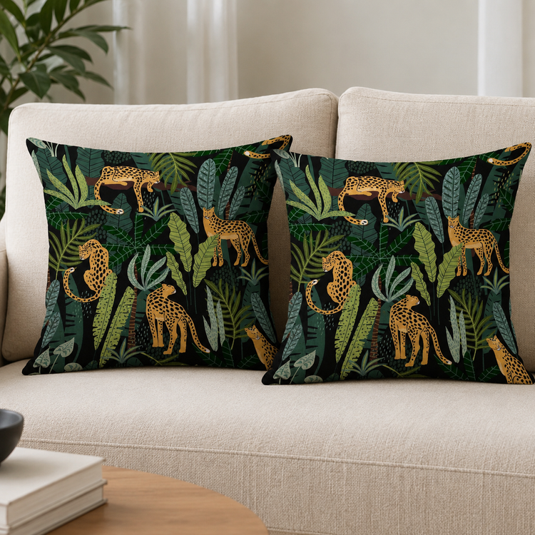 Two dark cushion covers with leopards and dense green tropical foliage on a sofa.