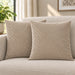 Two cream cushion covers with diagonal stitched lines on a cream sofa.