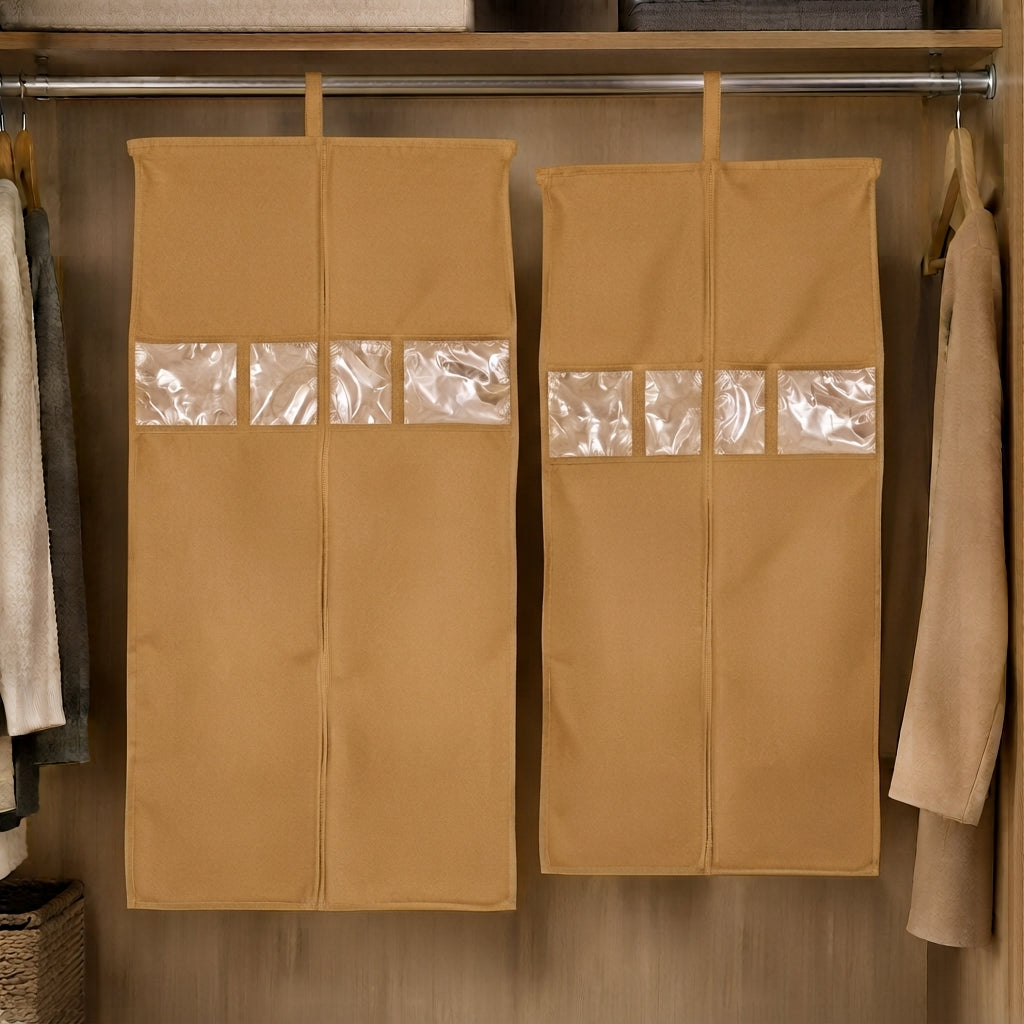 Two tan hanging garment covers with clear window panels inside a wooden wardrobe.