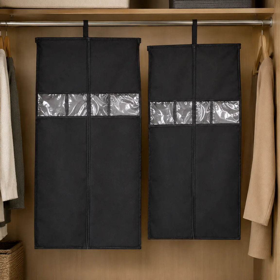 Two black hanging garment covers with clear window strips suspended from a metal wardrobe rod.