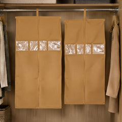Two tan hanging garment covers with clear window panels inside a wooden wardrobe.