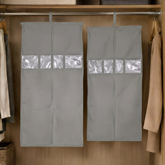 Two grey hanging garment covers with clear window panels inside a wooden wardrobe.