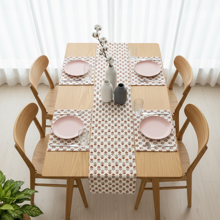 Cream table runner with small repeating red floral motifs and matching placemats.