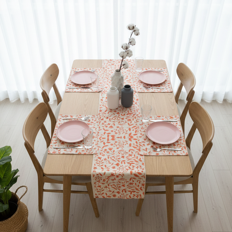 White table runner with orange botanical motifs and matching placemats.