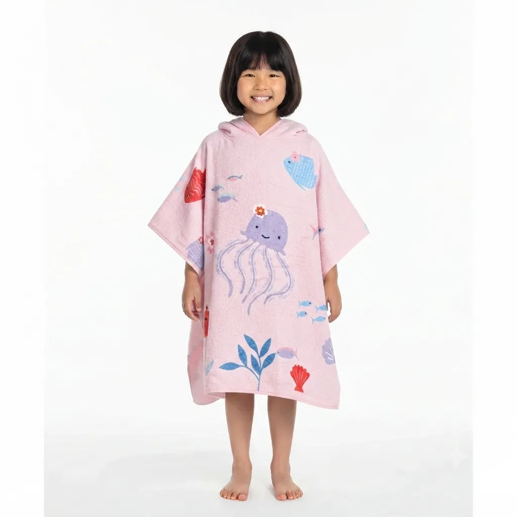 Child wearing a pink towel poncho with sea-life illustrations.
