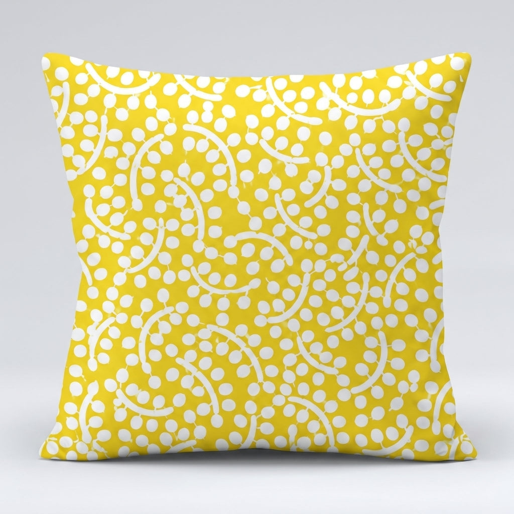 Yellow cushion cover with an intricate white dotted leaf-like pattern.