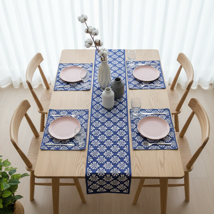 Blue table runner with white floral motifs and matching placemats.