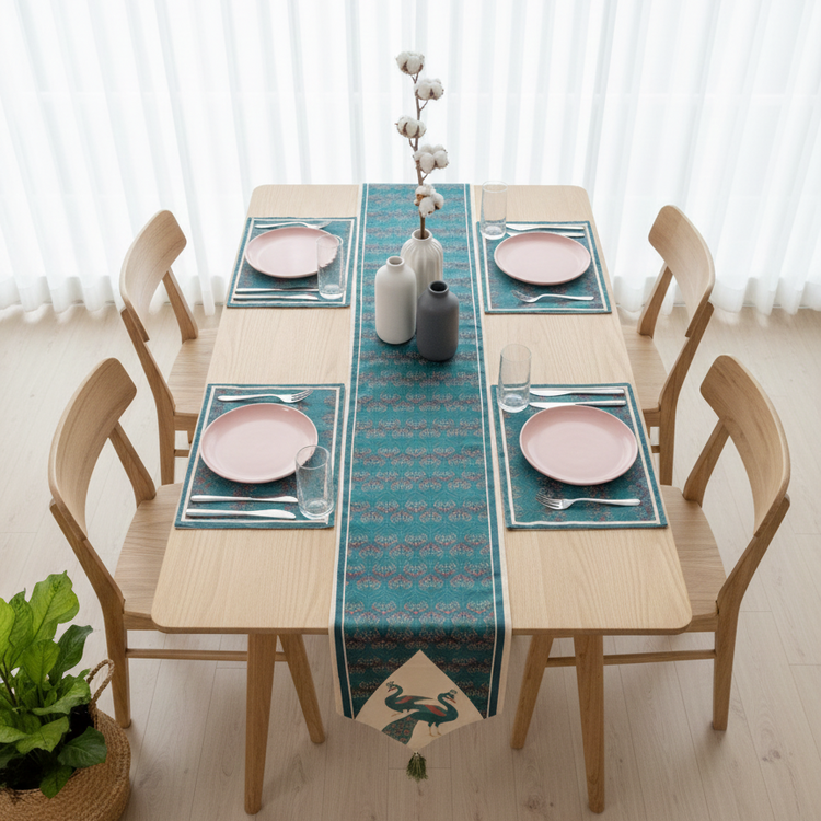 Teal ornamental table runner with peacock motifs and matching placemats.