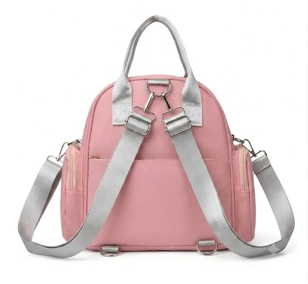 Rear view of a pink bag with gray adjustable backpack straps and carry handle