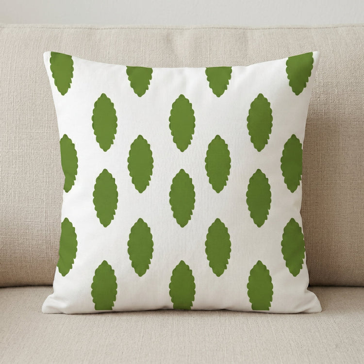 White cushion cover with small green leaf-like marks.