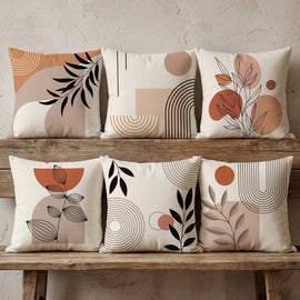 Six neutral cushion covers with terracotta abstract shapes and black botanical details.