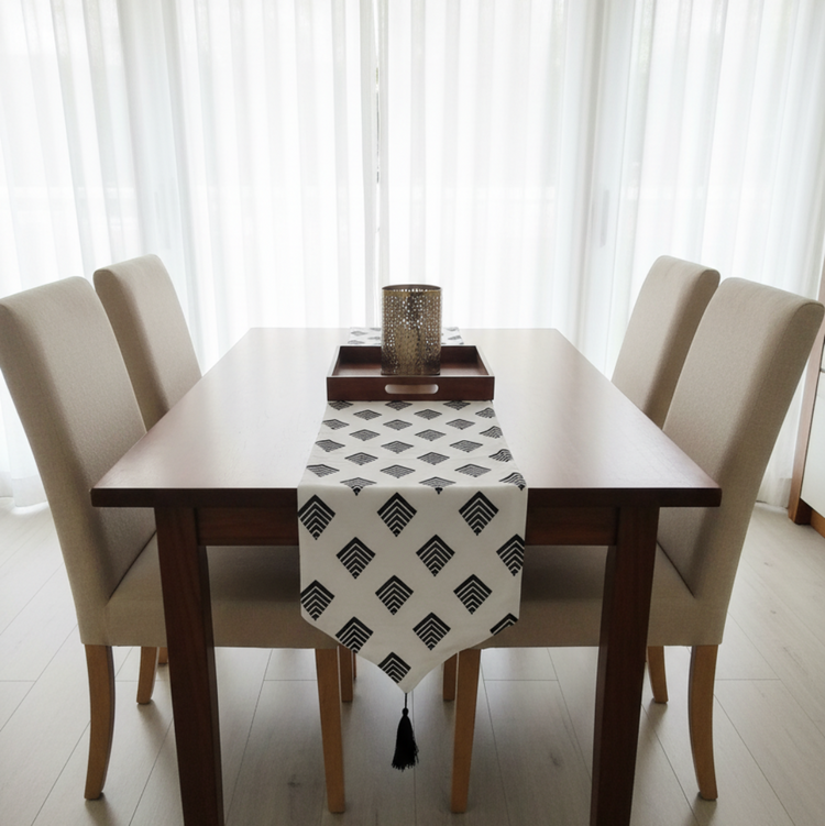 White table runner with repeating black diamond motifs.