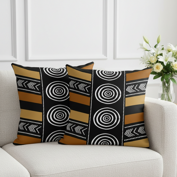 Two cushion covers with black and white circles and mustard horizontal stripes on a sofa.