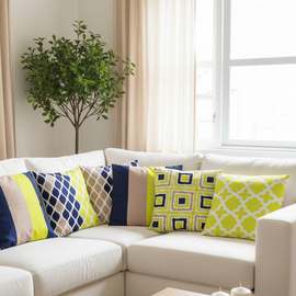Six navy, yellow, grey and white geometric cushion covers arranged on a white corner sofa.