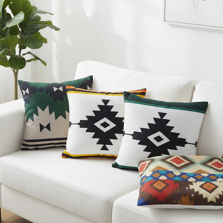 Cream and dark green cushion covers with black geometric diamonds on a sofa.