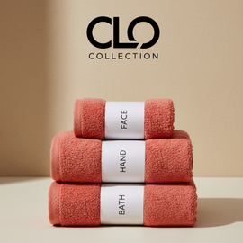 Reddish-orange face, hand and bath towels stacked with labelled bands.