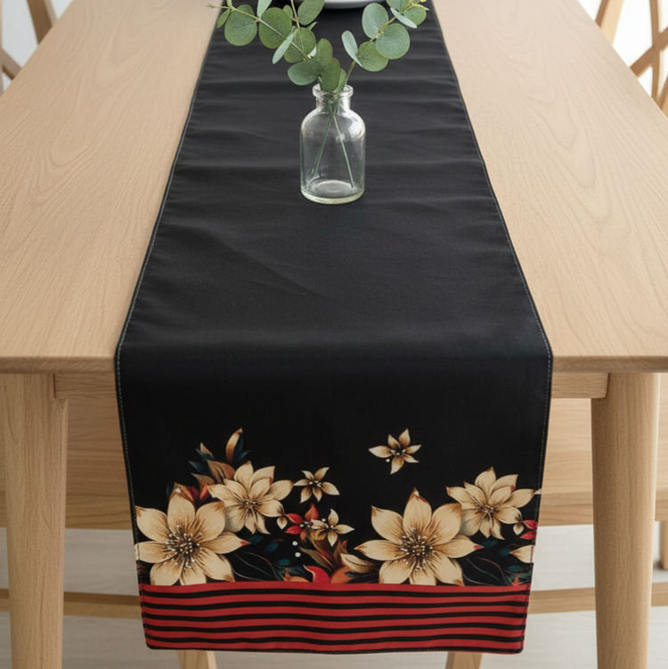 Black table runner with cream flowers and a red striped border.