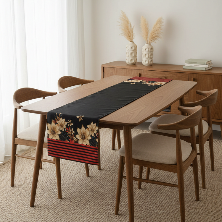 Black table runner with cream flowers and a red striped border.