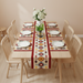 Colourful geometric table runner with red borders and matching placemats on a dining table.