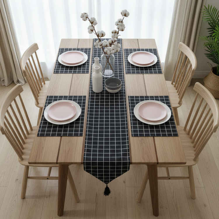 Black grid-pattern table runner with matching placemats and a tasselled end.