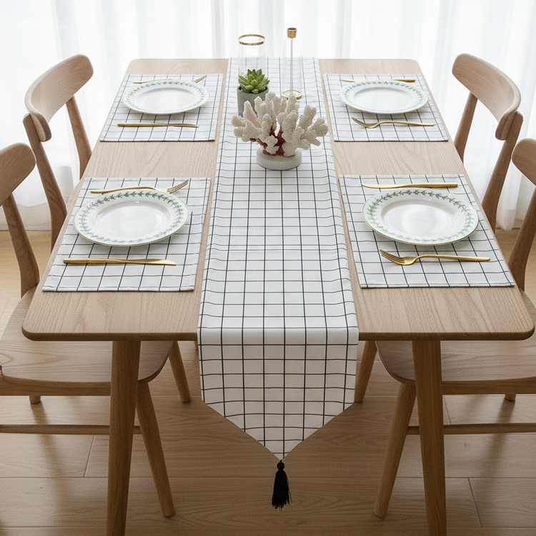 White grid-pattern table runner with matching placemats and a black tassel.