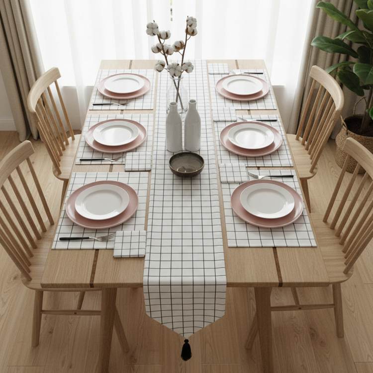 White grid-pattern table runner with matching placemats and a black tassel.